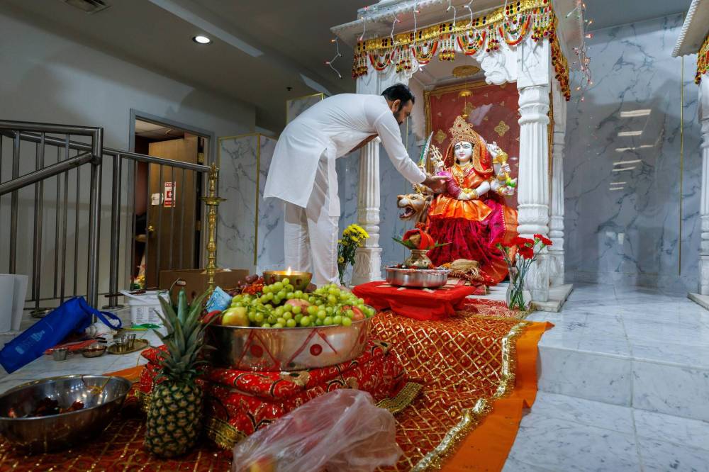 MIKE DEAL / FREE PRESS
Pandit Shrikant Sharma performs rituals for the Goddess Durga murti at the Hindu Society of Manitoba temple on St. Anne’s Road.