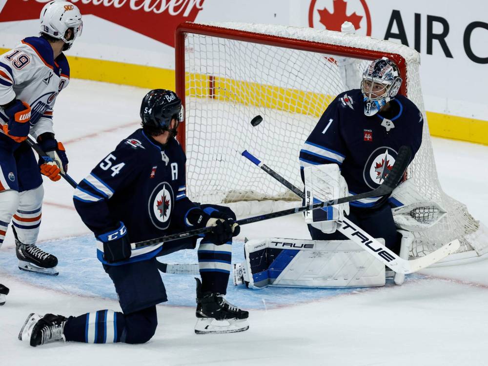 JOHN WOODS / FREE PRESS
Winnipeg Jets’ Dylan Samberg (54) and Edmonton Oilers’ Adam Henrique (19) look on as a shot gets past goaltender Eric Comrie during second period pre-season NHL action in Winnipeg on Tuesday.