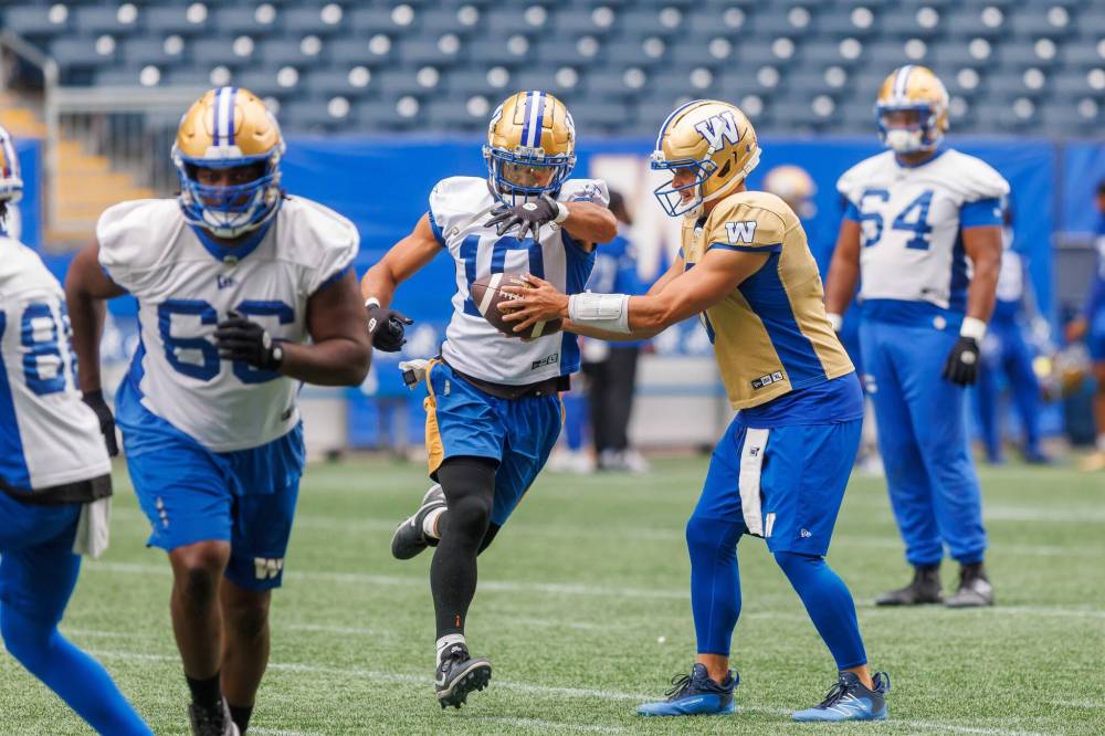 MIKE DEAL / FREE PRESS
Bombers QB Zach Collaros (right) hands the ball off to Nic Demski on Tuesday during practice at Princess Auto Stadium.