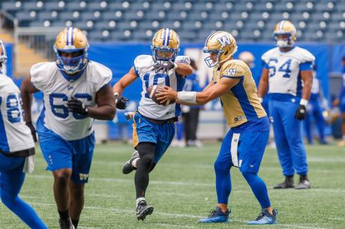 MIKE DEAL / FREE PRESS
                                Bombers QB Zach Collaros (right) hands the ball off to Nic Demski on Tuesday during practice at Princess Auto Stadium.