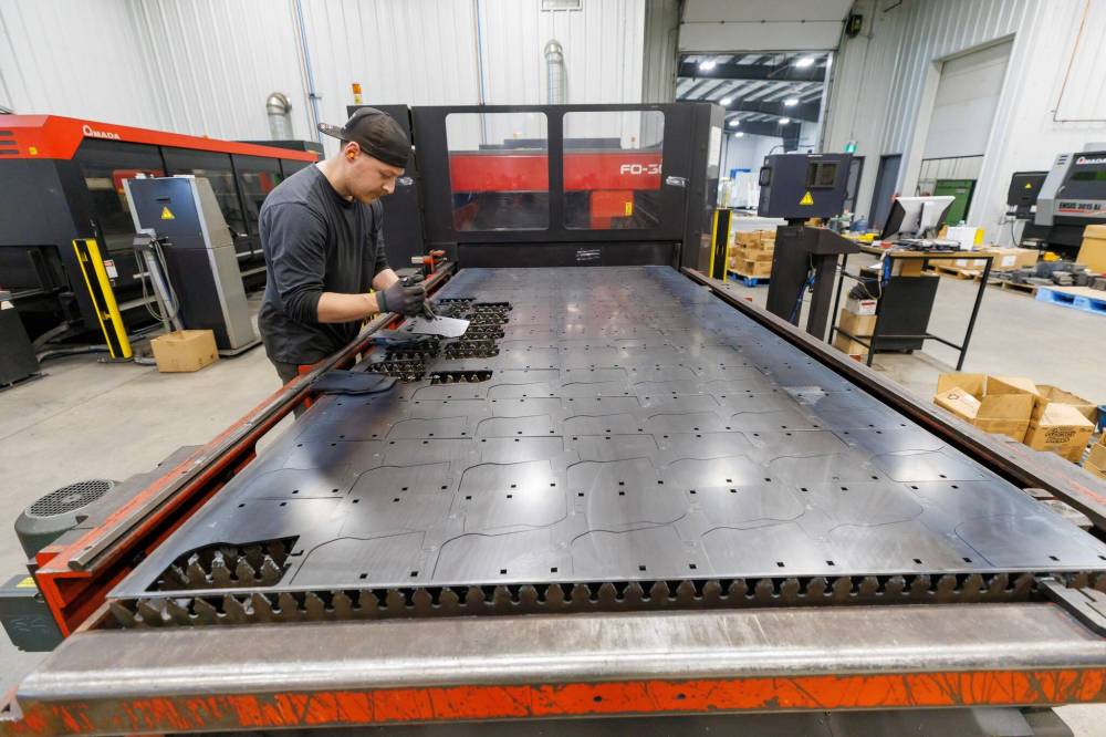 MIKE DEAL / FREE PRESS
Brandon Koch sorts pieces of steel destined for use in an agricultural machine.