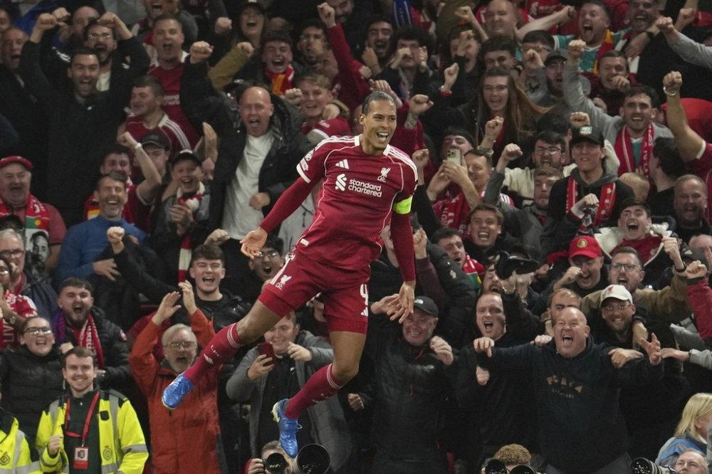Liverpool's Virgil van Dijk celebrates after scoring his side's third goal during the Champions League opening phase soccer match between Liverpool and Atletico Madrid at Anfield stadium in Liverpool, England, Wednesday, Sept. 17, 2025. (AP Photo/Jon Super)