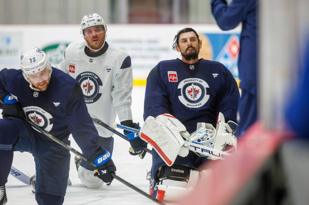 MIKE DEAL / FREE PRESS FILES
Winnipeg Jets’ Ethan Frisch (73), Dylan Samberg (54), and goalie Connor Hellebuyck (37) hit the ice during training camp on Sept. 18. Hellebuyck missed Monday’s practice, but was in the lineup in Tuesday’s pre-season game, while Samberg is out with a broken wrist.