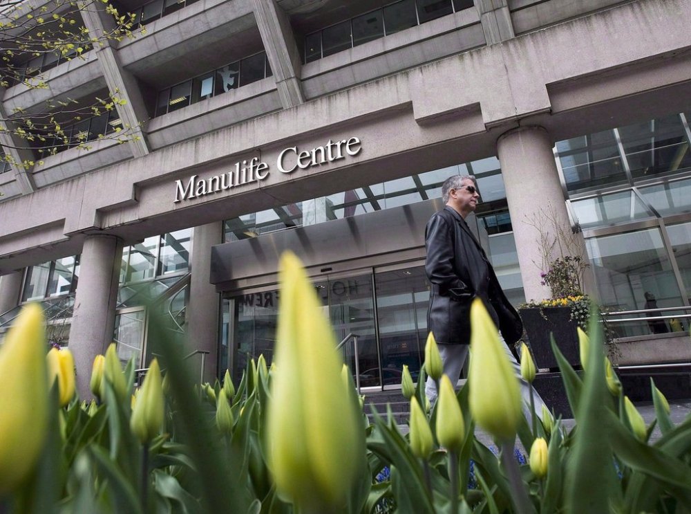 A man walks by the Manulife Centre in Toronto on the day of the Manulife Financial annual general meeting on Thursday, May 3, 2012. THE CANADIAN PRESS/Aaron Vincent Elkaim
