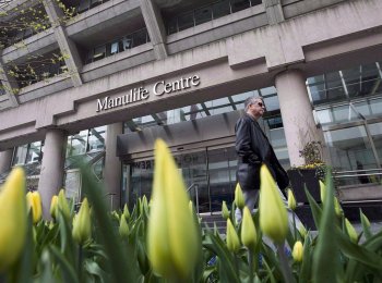 A man walks by the Manulife Centre in Toronto on the day of the Manulife Financial annual general meeting on Thursday, May 3, 2012. THE CANADIAN PRESS/Aaron Vincent Elkaim