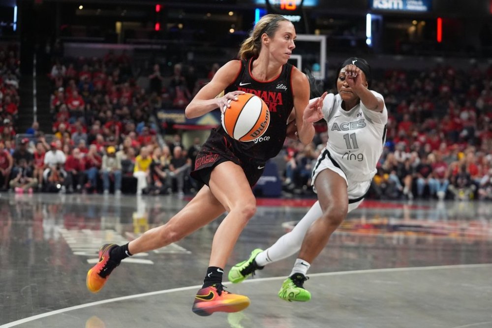 Indiana Fever's Lexie Hull, left, goes to the basket against Las Vegas Aces' Dana Evans during second half of Game 3 of a WNBA basketball playoff semifinals series, Friday, Sept. 26, 2025, in Indianapolis. (AP Photo/Darron Cummings)