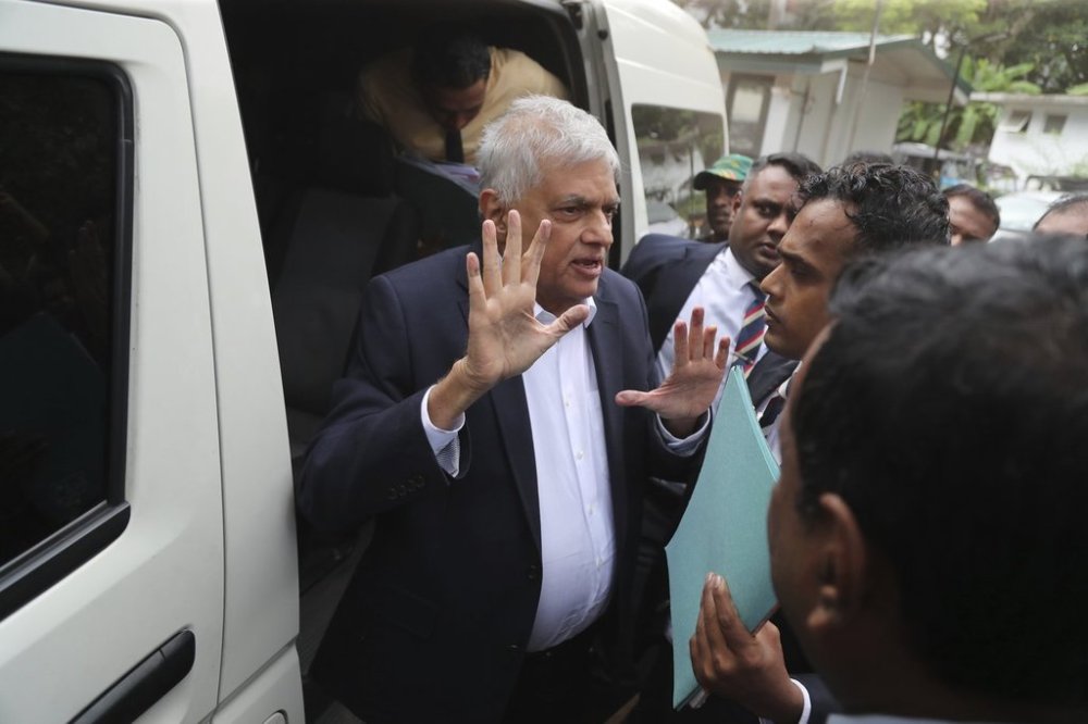 Former Sri Lankan President Ranil Wickremesinghe, center, is escorted to court by police in Colombo, Sri Lanka, Friday, Aug. 22, 2025. (AP Photo/Lahiru Harshana)