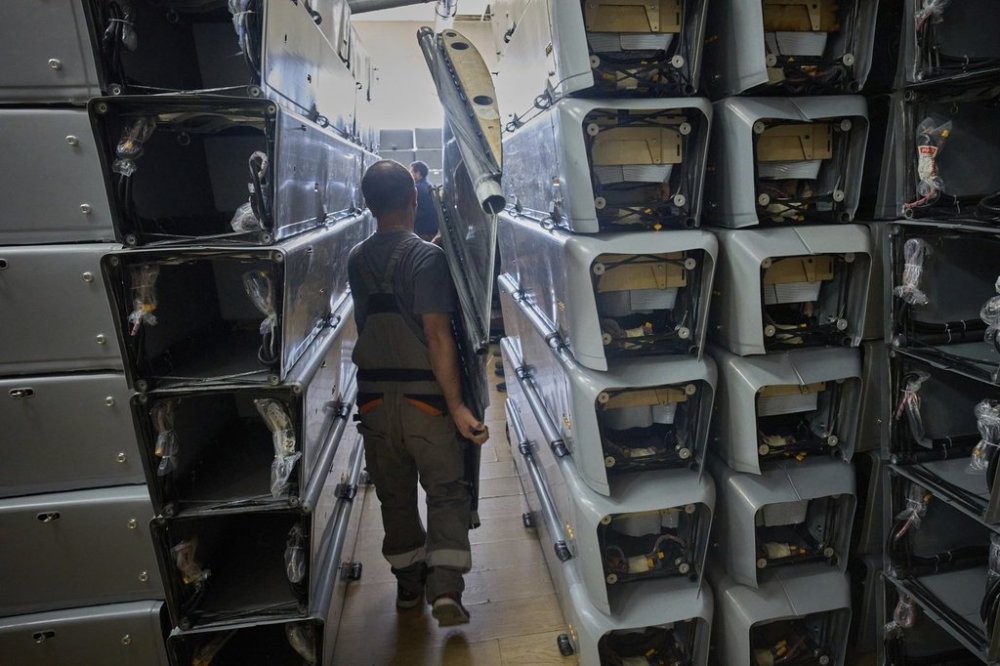 FILE -A worker carries part of a combat drone at Fire Point's secret factory in Ukraine on, Aug. 14, 2025. (AP Photo/Efrem Lukatsky, File)