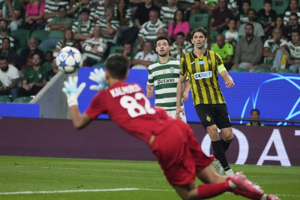 Sporting's Pedro Goncalves and Kairat's Alyaksandr Martynovich, right, watch as Kairat's goalkeeper Sherhan Kalmurza dives for a save during the Champions League opening phase soccer match between Sporting CP and Kairat Almaty at the Alvalade stadium in Lisbon, Thursday, Sept. 18, 2025. (AP Photo/Ana Brigida)