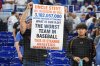 A fan holds up a sign referring to the New York Mets after the Mets lost to the Miami Marlins in a baseball game, Sunday, Sept. 28, 2025, in Miami. (AP Photo/Lynne Sladky)