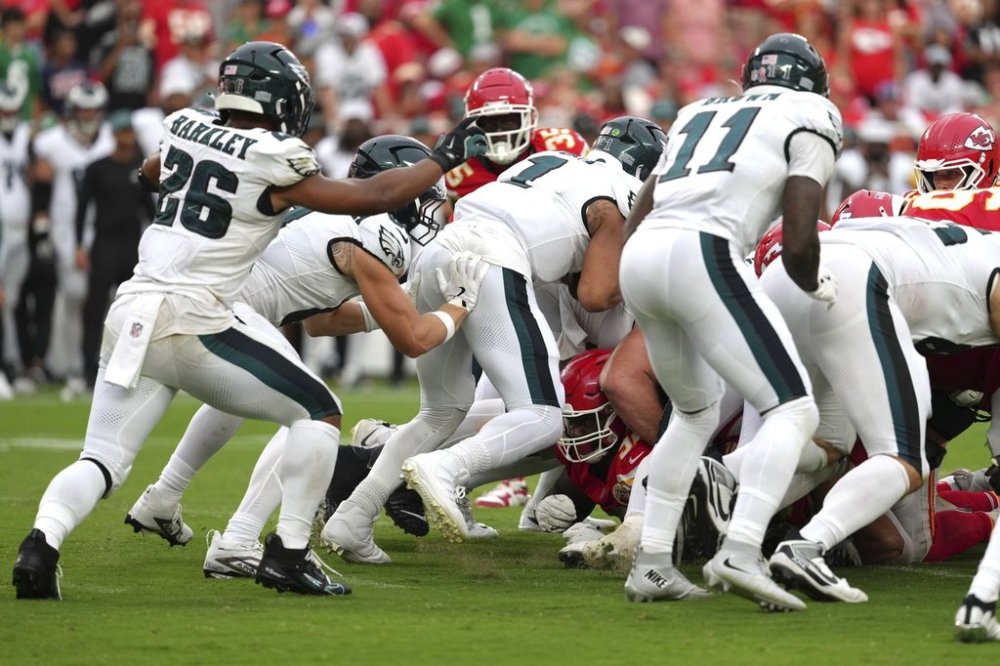 Philadelphia Eagles quarterback Jalen Hurts (1) gets a push from behind from Philadelphia Eagles tight end Grant Calcaterra (81) agains the Kansas City Chiefs in the second half during an NFL football game Sunday, Sept. 14, 2025, in Kansas City, Mo. (AP Photo/Ed Zurga)