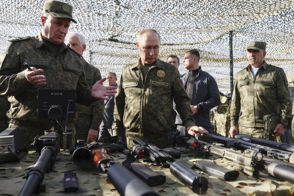 Russian President Vladimir Putin, centre, accompanied by Commander-in-Chief of the Russian Ground Forces Andrey Mordvichev, left, inspects Russian weapons and equipment during his visit to the Russian-Belarusian joint military drills