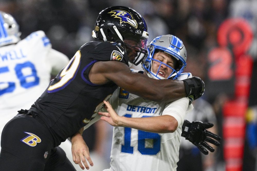 Detroit Lions quarterback Jared Goff, right, takes a hit from Baltimore Ravens linebacker Odafe Oweh after throwing a pass during the first half of an NFL football game Monday, Sept. 22, 2025, in Baltimore. (AP Photo/Nick Wass)