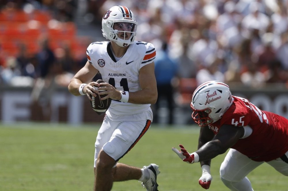 Auburn quarterback Jackson Arnold (11) scrambles away from South Alabama defensive lineman Ed Smith IV (45) during the first half of an NCAA college football game, Saturday, Sept. 13, 2025, in Auburn, Ala. (AP Photo/Butch Dill)