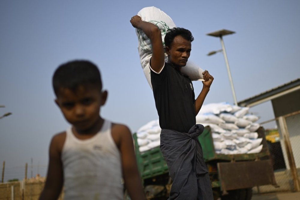 A Rohingya refugee carries a food ration sack on his back from a distribution center in Cox's Bazar, Bangladesh, March 13, 2025. (AP Photo/Mahmud Hossain Opu)