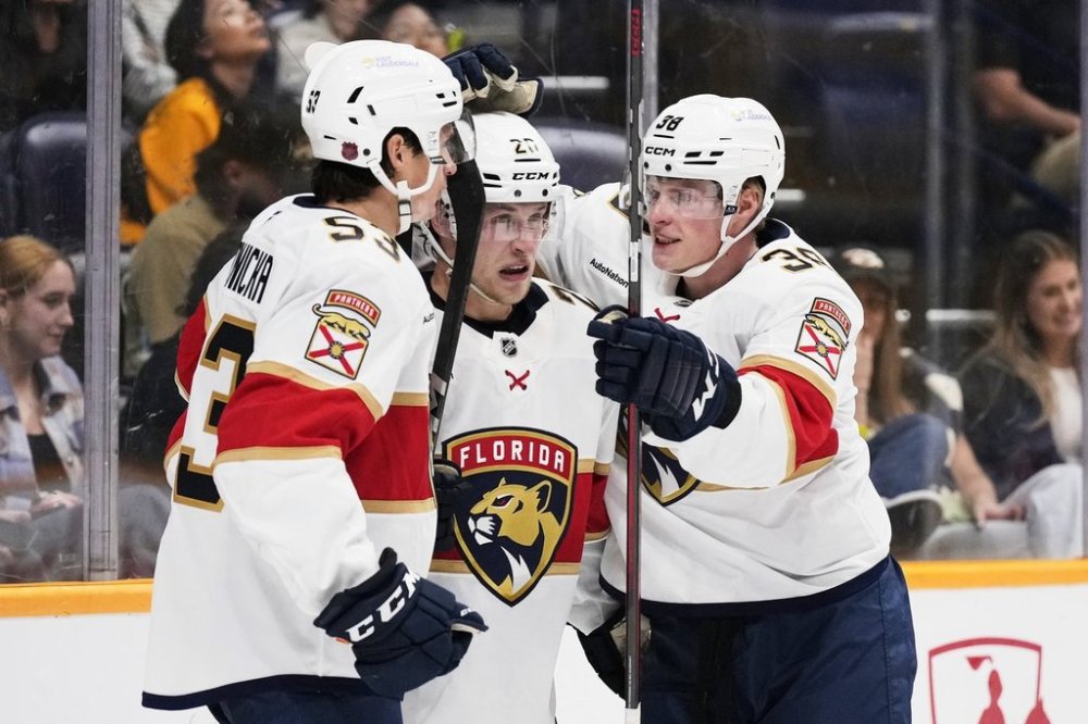 Florida Panthers defenseman Mike Benning (20) is congratulated after his goal by center Jack Studnicka (53) and right wing Jack Devine (38)during the third period of an NHL preseason hockey game Sunday, Sept. 21, 2025, in Nashville, Tenn. (AP Photo/George Walker IV)