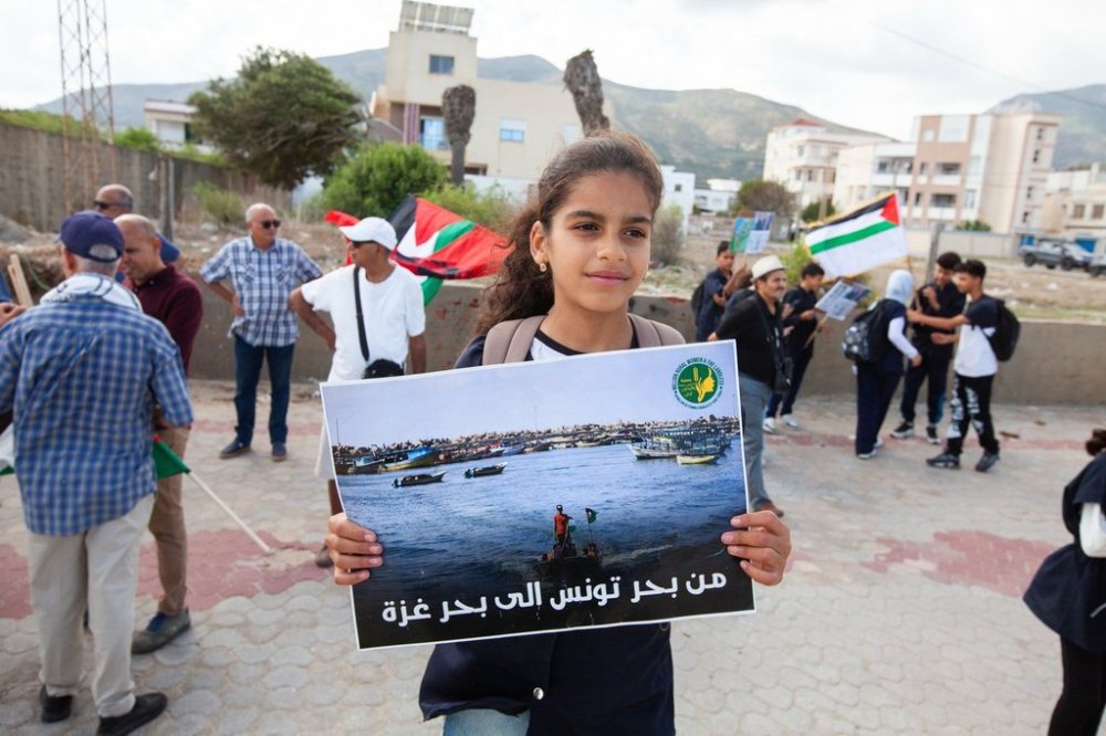 Demonstrators gather at a memorial site honoring the victims of the 1985 Israeli attack on Palestine Liberation Organization's headquarters, in Hammam Chott outside Tunisia's capital, Wednesday, Oct. 1, 2025. Banner in Arabic reads