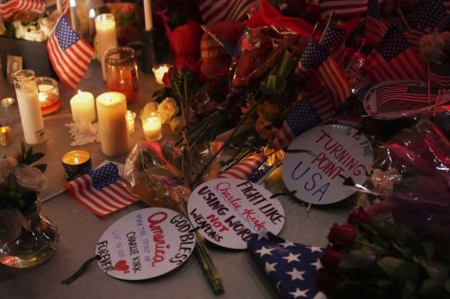 Flags, candles and signs sit at a vigil for Charlie Kirk, the CEO and co-founder of Turning Point USA who was shot and killed, Thursday, Sept. 11, 2025, in Orem, Utah. (AP Photo/Lindsey Wasson)