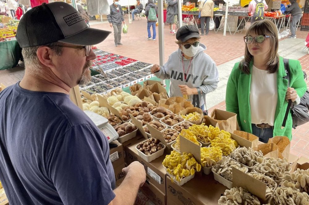 Angie Crone, Upcycled Food Association CEO, right, speaks to a mushroom farmer who sells