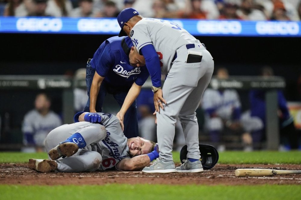 Los Angeles Dodgers' Dalton Rushing, bottom left, reacts after an injury during the sixth inning of a baseball game against the Baltimore Orioles, Friday, Sept. 5, 2025, in Baltimore. (AP Photo/Stephanie Scarbrough)