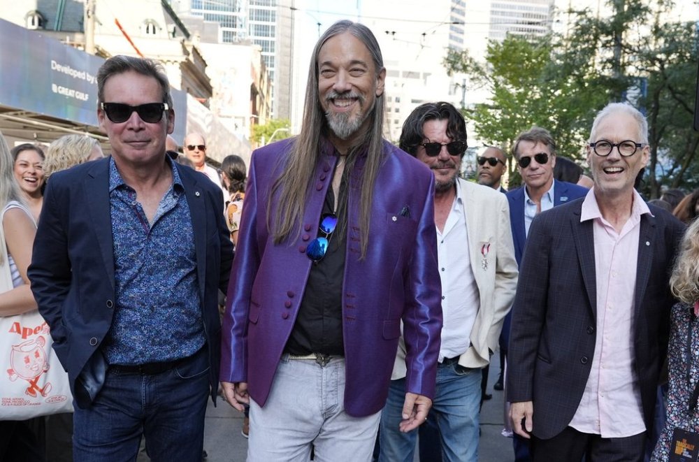 The Tragically Hip band members, from left, Gord Sinclair, Rob Baker, Paul Langlois (light jacket) and Johnny Fay, far right, walk from the premiere of a documentary film about them,