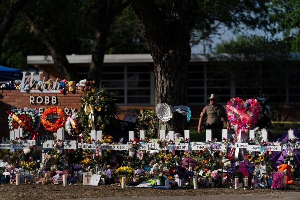 FILE - Flowers and candles are placed around crosses on May 28, 2022, at a memorial outside Robb Elementary School in Uvalde, Texas, to honor the victims killed in the school shooting. (AP Photo/Jae C. Hong, File)