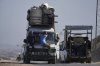 Displaced Palestinians fleeing northern Gaza carry their belongings along the coastal road toward southern Gaza, Tuesday, Sept. 9, 2025, after the Israeli army issued evacuation orders from Gaza City. (AP Photo/Jehad Alshrafi)