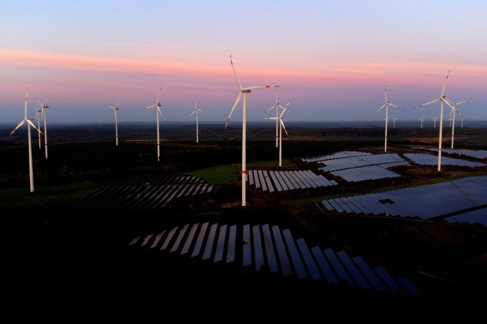 FILE - Wind turbines operate as the sun rises at the Klettwitz Nord solar energy park near Klettwitz, Germany, Oct. 16, 2024. (AP Photo/Matthias Schrader, File)