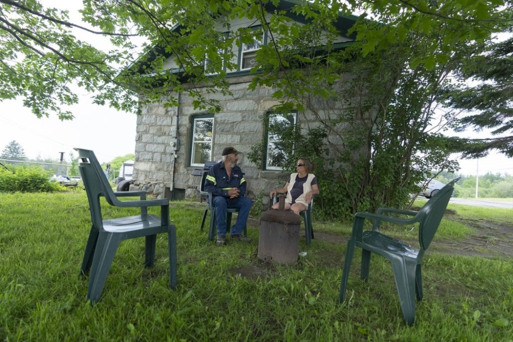 Rita Boulanger and Raymond Savoie sit outside their home in Lac-Mégantic, Que., on July 6, 2023. THE CANADIAN PRESS/Christinne Muschi