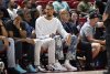 FILE - San Antonio Spurs' Victor Wembanyama, center, sits court side during the first half of an NBA summer league basketball game between the Spurs and Philadelphia 76ers, July 10, 2025, in Las Vegas. (AP Photo/David Becker, File)