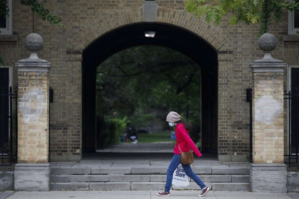 A person carrying a University of Toronto Book Store shopping bag walks on the University of Toronto campus in Toronto, on Sept. 8, 2020. THE CANADIAN PRESS/Cole Burston