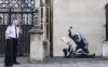 Undated photo released by Banksy of the new artwork by the artist which portrays a judge beating a protester with a gavel at the Royal Courts of Justice in London. (Banksy via AP)