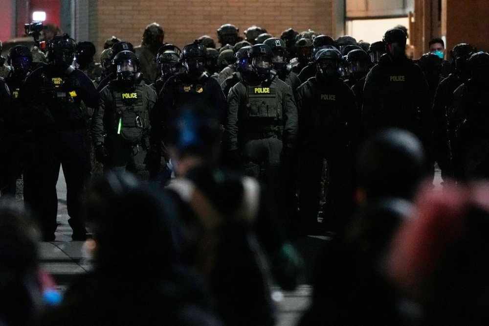 Law enforcement officers standoff against demonstrators outside a U.S. Immigration and Customs Enforcement facility during a protest on Saturday, Oct. 4, 2025, in Portland, Ore. (AP Photo/Jenny Kane)