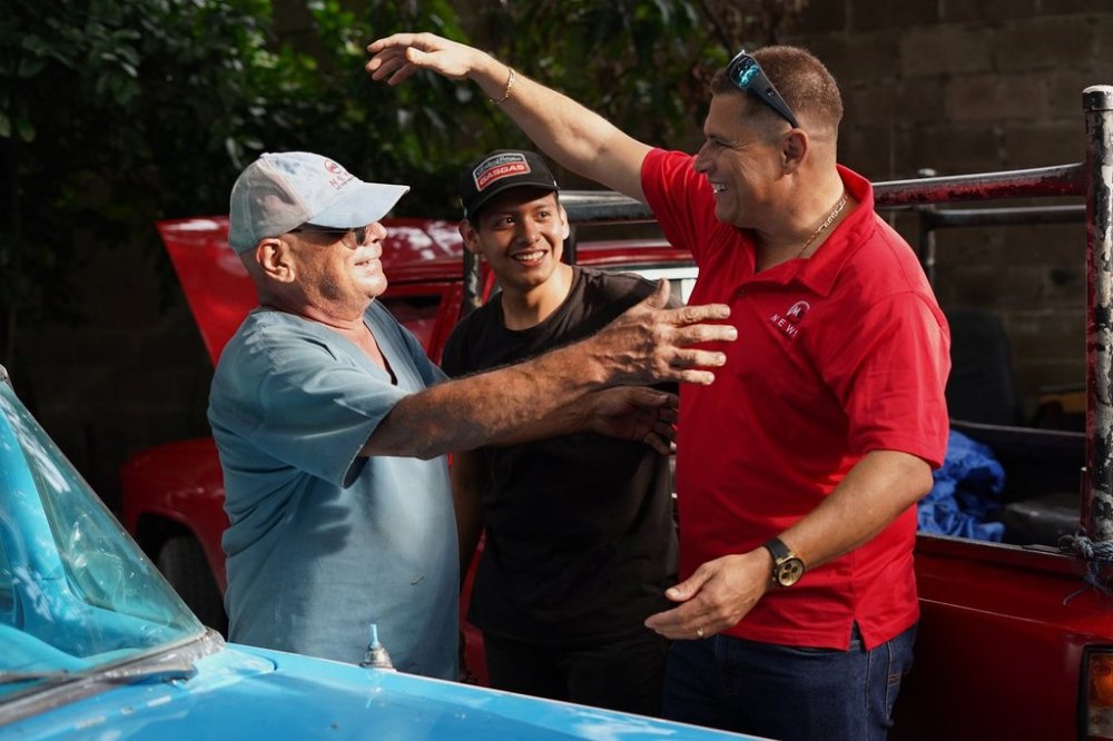 Salvadoran journalist Mario Guevara, right, greets neighbors after arriving at a relative's home in Apopa, El Salvador, following his deportation from the United States, Friday, Oct. 3, 2025. (AP Photo/Salvador Melendez)