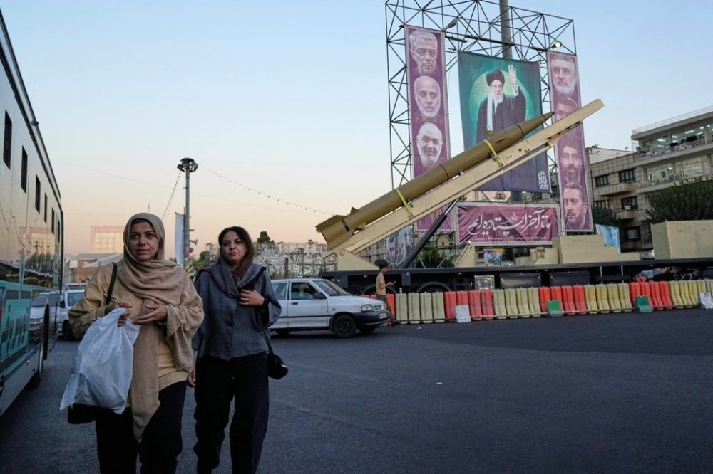 People walk past a domestically-built missile