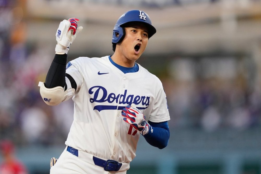 Los Angeles Dodgers' Shohei Ohtani celebrates as he rounds the bases after his solo home run during the first inning in Game 1 of the National League Wild Card baseball playoff series against the Cincinnati Reds, Tuesday, Sept. 30, 2025, in Los Angeles. (AP Photo/Mark J. Terrill)