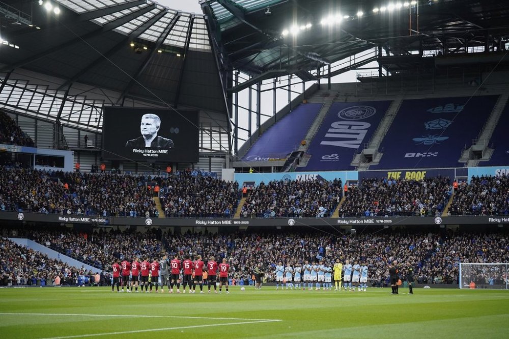Players stand during a minute of silence for a former boxer Ricky Hatton before the Premier League soccer match between Manchester City and Manchester United in Manchester, England, Sunday, Sept. 14, 2025. (AP Photo/Dave Thompson)