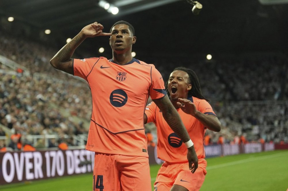 Barcelona's Marcus Rashford, left, celebrates after scoring his side second goal with Jules Kounde during the Champions League, opening phase soccer match between Newcastle and Barcelona in Newcastle, England, Thursday, Sept. 18, 2025. (AP Photo/Jon Super)