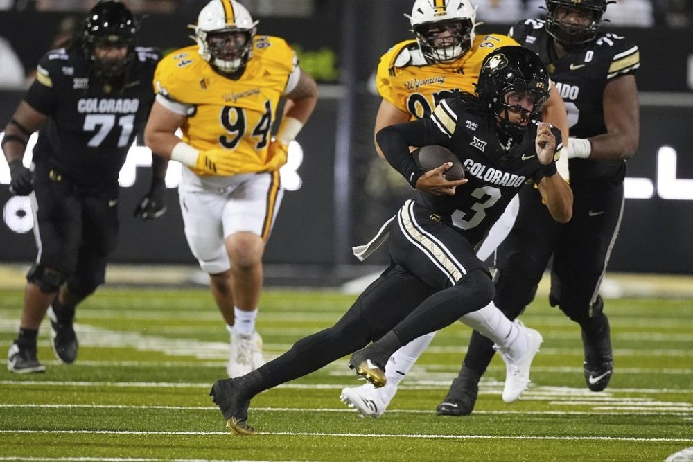 Colorado quarterback Kaidon Salter (3) runs for a short gain as Wyoming nose tackle Ben Florentine (94) and defensive tackle Lucas Samsula (97) pursue in the first half of an NCAA college football game Saturday, Sept. 20, 2025, in Boulder, Colo. (AP Photo/David Zalubowski)