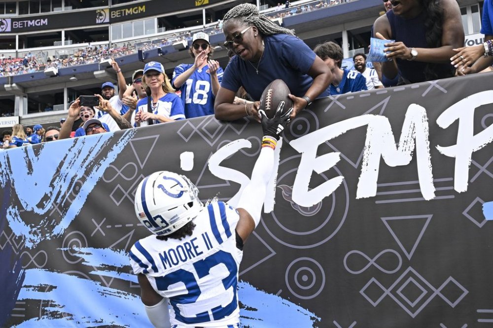 Indianapolis Colts cornerback Kenny Moore II (23) hands the ball to a fan after scoring a touchdown on an interception against the Tennessee Titans during the first half of an NFL football game Sunday, Sept. 21, 2025, in Nashville, Tenn. (AP Photo/John Amis)