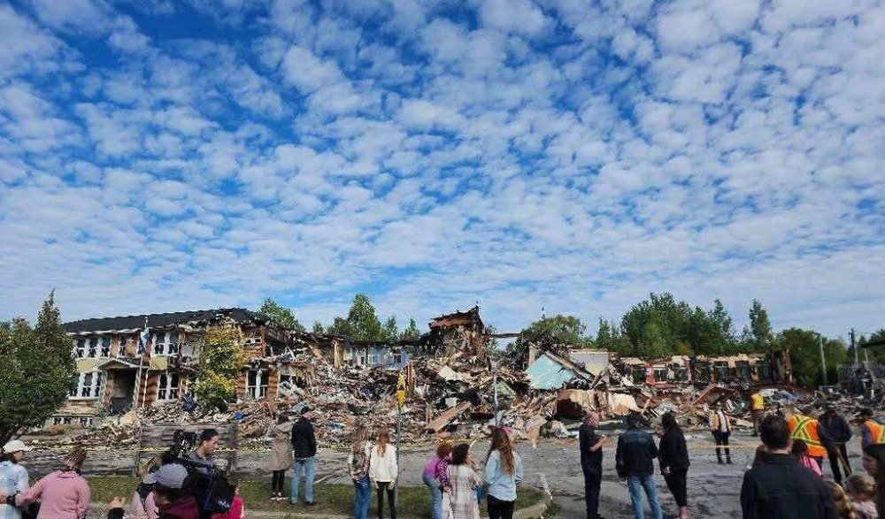 Community members gather around the site of a fire at a school in Prévost, Que., in a Saturday, Sept. 13, 2025, handout photo. THE CANADIAN PRESS/Handout - Mélanie Poitras (Mandatory Credit)