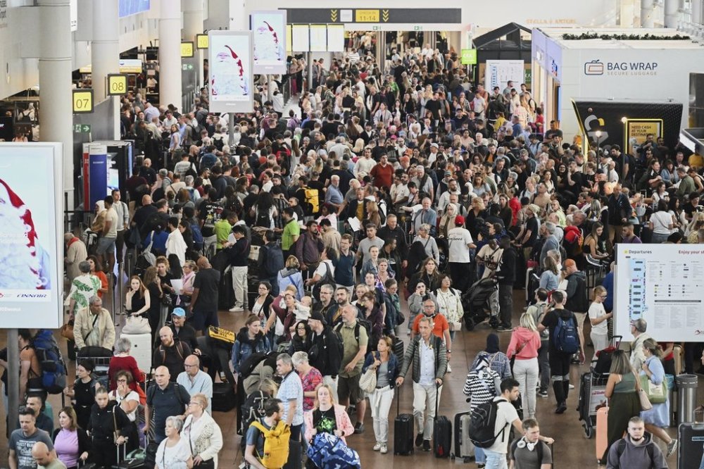 People walk by a departures board after a cyber attack caused delays at Brussels International Airport in Zaventem, Belgium, Saturday, Sept. 20, 2025. (AP Photo/Harry Nakos)