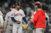 Boston Red Sox pitcher Brayan Bello hands the ball to Boston Red Sox manager Alex Cora as he leaves the game in the third inning of Game 2 of an American League wild-card baseball playoff series against the New York Yankees, Wednesday, Oct. 1, 2025, in New York. (AP Photo/Yuki Iwamura)
