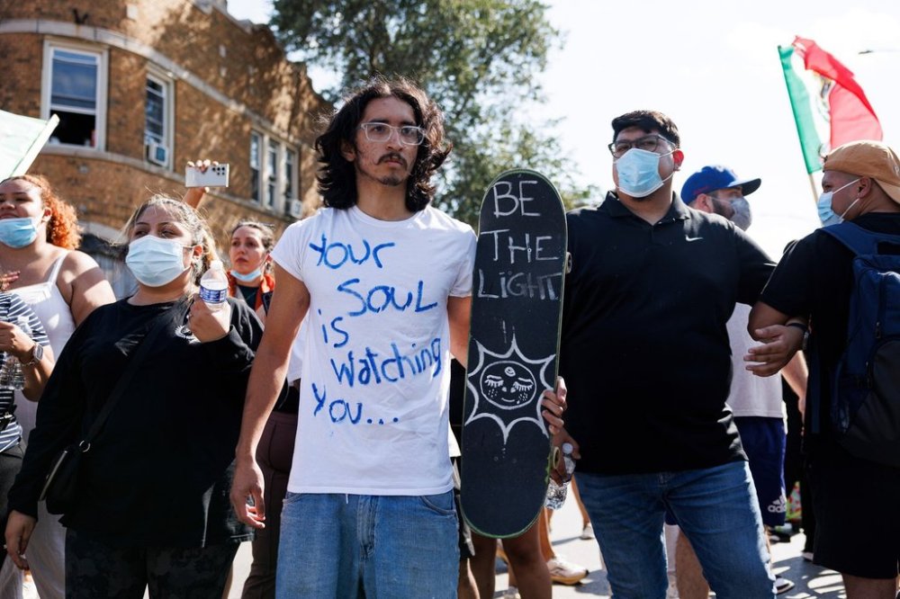 Protesters stand and chant in the Brighton Park neighborhood of Chicago, on Saturday, Oct. 4, 2025, after protesters learned that U.S. Border Patrol shot a woman Saturday morning on Chicago's Southwest Side. (Anthony Vazquez/Chicago Sun-Times via AP)
