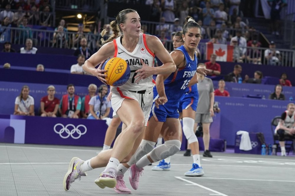 Canada's Paige Crozon (7) drives past Hortense Limouzin (15), of France, in the women's 3x3 basketball pool round match during the 2024 Summer Olympics, Thursday, Aug. 1, 2024, in Paris, France. Canada won 13-9. (AP Photo/Frank Franklin II)