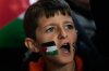 A boy with a Palestinian flag painted on his face chants slogans during a gathering outside Istanbul Airport, as people wait for the arrival of 137 activists from the Global Sumud Flotilla, in Istanbul, Turkey, Saturday, Oct. 4, 2025. (AP Photo/Khalil Hamra)