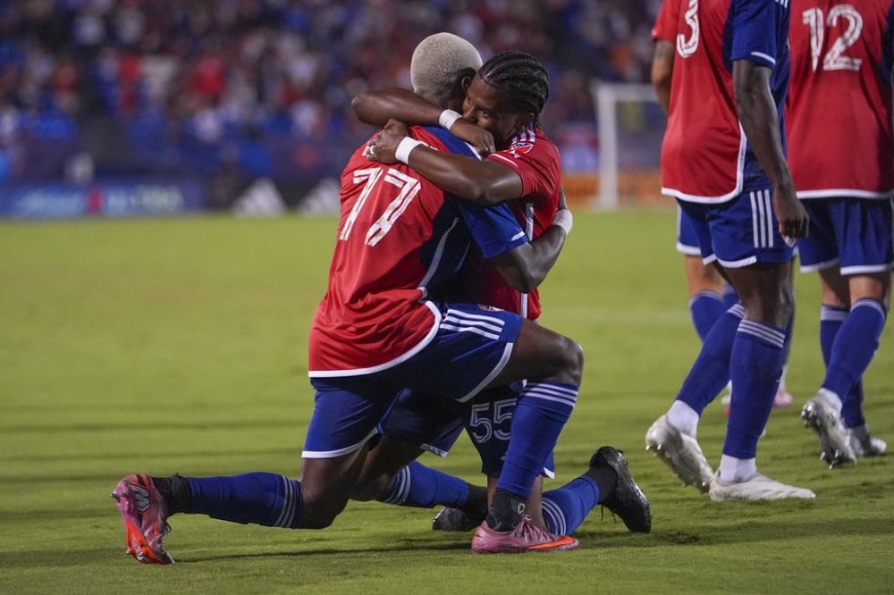 FC Dallas forward Bernard Kamungo (77) is congratulated by Kaick after scoring a goal on Nico van Rijn during the second half of an MLS soccer match Saturday, Sept. 13, 2025, in Frisco, Texas. (AP Photo/Julio Cortez)