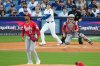 Los Angeles Dodgers' Shohei Ohtani watches his solo home run off Cincinnati Reds starting pitcher Hunter Greene (21) during the first inning in Game 1 of the National League Wild Card baseball playoff series Tuesday, Sept. 30, 2025, in Los Angeles. (AP Photo/Mark J. Terrill)