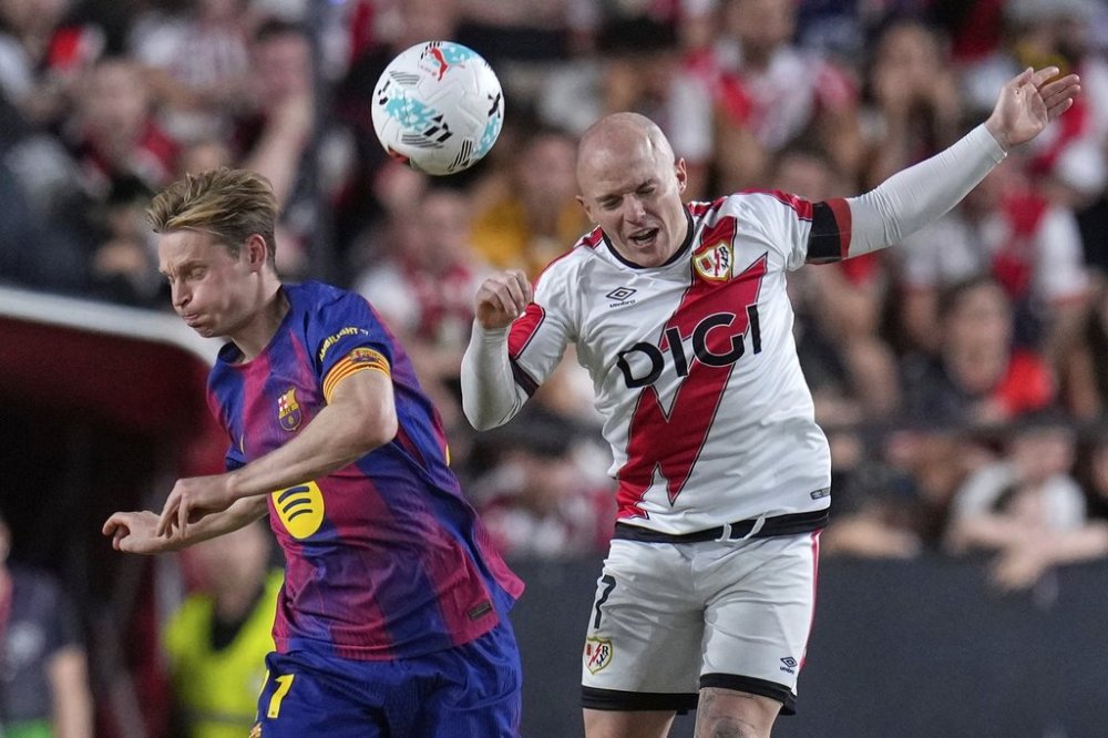 Barcelona's Frenkie de Jong, left, and Rayo's Isi Palazon battle for the ball during the Spanish La Liga soccer match between Rayo Vallecano and FC Barcelona at the Vallecas stadium in Madrid, Spain, Sunday, Aug. 31, 2025. (AP Photo/Manu Fernandez)