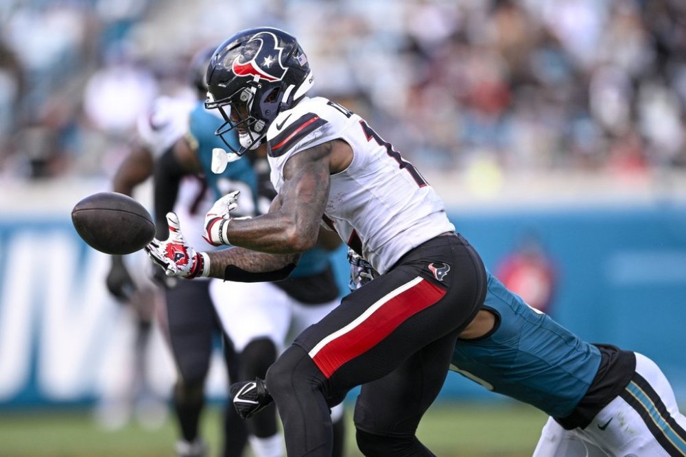 Houston Texans wide receiver Nico Collins, front, fumbles the ball after taking a hit from Jacksonville Jaguars cornerback Tyson Campbell during the second half of an NFL football game Sunday, Sept. 21, 2025, in Jacksonville, Fla. (AP Photo/Phelan M. Ebenhack)